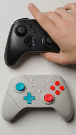 Vertical-Video-Overhead-Studio-Shot-Hand-Reaching-Choosing-Video-Game-Controller